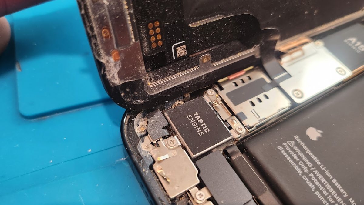 Corrosion inside a water-damaged iPhone before ultrasonic cleaning