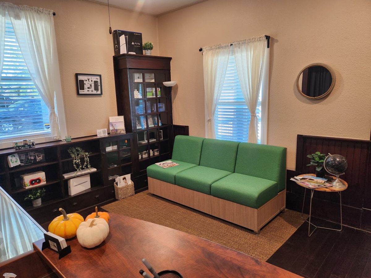 Waiting area at Device Hero with a green couch and accessories on display